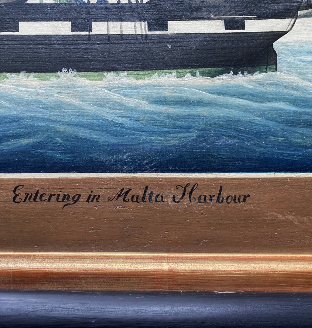 An early 19th-century marine oil painting depicting a two-masted brig ship sailing into Malta harbour, set within a black and gilt wooden frame. View XVII