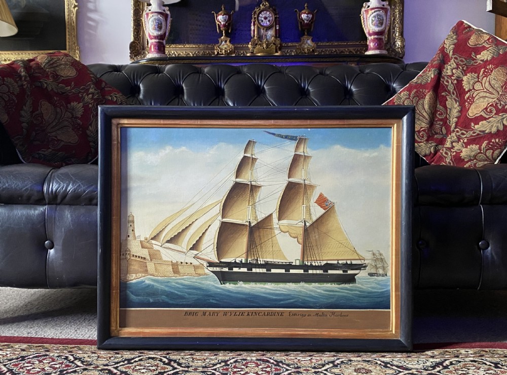 An early 19th-century marine oil painting depicting a two-masted brig ship sailing into Malta harbour, set within a black and gilt wooden frame. View XX