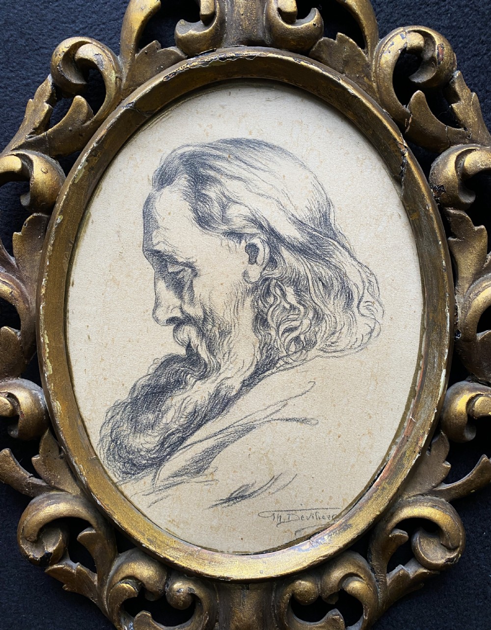 An oval charcoal profile drawing on paper depicting a bearded man with long hair, set inside a carved gold leaf Florentine frame. View III