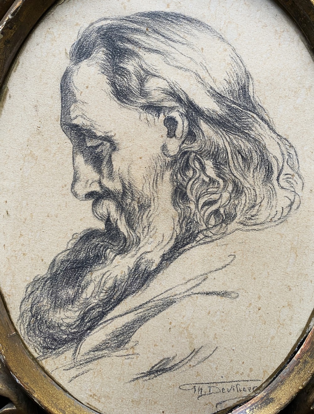 An oval charcoal profile drawing on paper depicting a bearded man with long hair, set inside a carved gold leaf Florentine frame. View IV