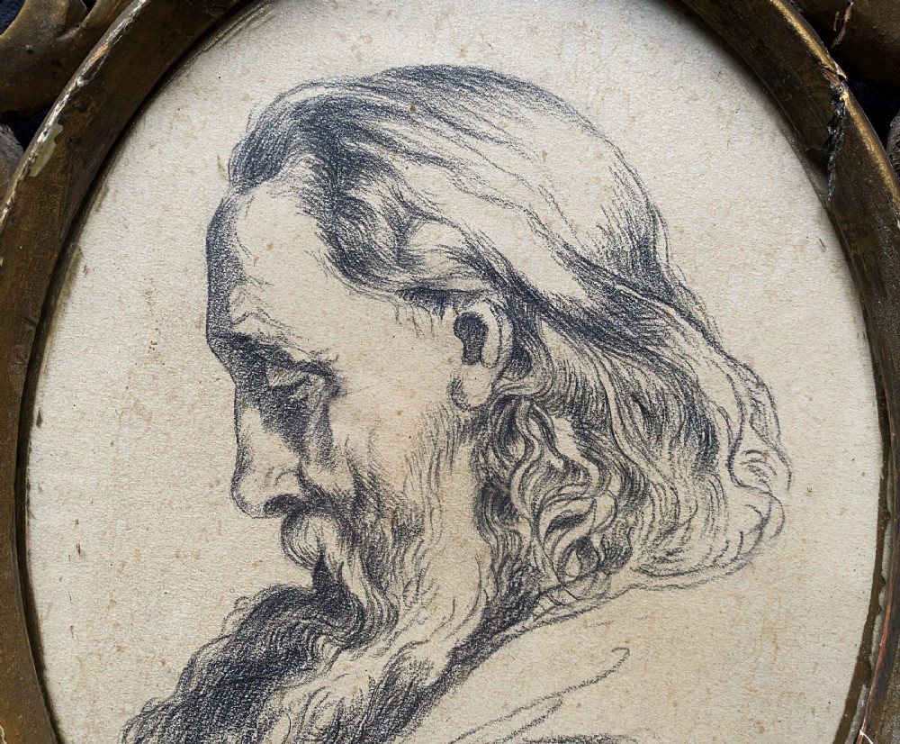 An oval charcoal profile drawing on paper depicting a bearded man with long hair, set inside a carved gold leaf Florentine frame. View V