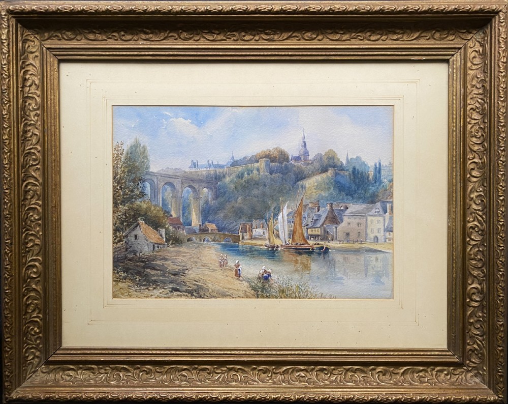 A framed 19th-century watercolour painting depicting a river scene with boats, a stone viaduct, and a hillside town set within an ornate gilded frame.
