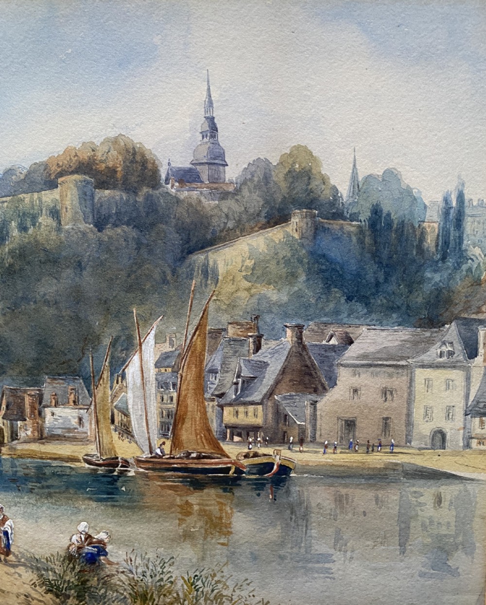 A framed 19th-century watercolour painting depicting a river scene with boats, a stone viaduct, and a hillside town set within an ornate gilded frame. View VI