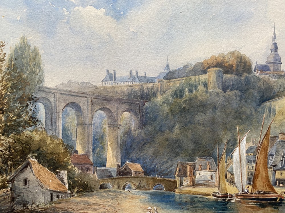 A framed 19th-century watercolour painting depicting a river scene with boats, a stone viaduct, and a hillside town set within an ornate gilded frame. View VII