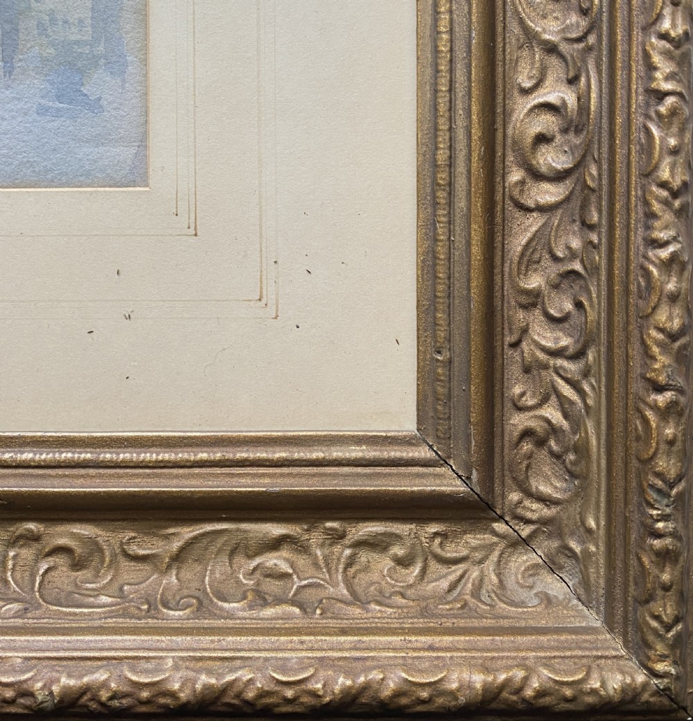 A framed 19th-century watercolour painting depicting a river scene with boats, a stone viaduct, and a hillside town set within an ornate gilded frame. View X