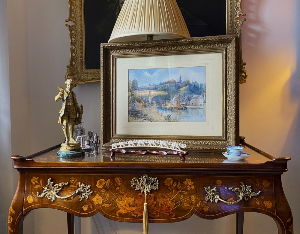 A framed 19th-century watercolour painting depicting a river scene with boats, a stone viaduct, and a hillside town set within an ornate gilded frame. View XIII