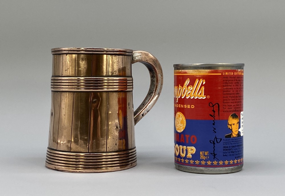 A tapered late Georgian copper tankard featuring horizontal reeded bands, vertical staved lines, and a curved nickel-plated handle. View II
