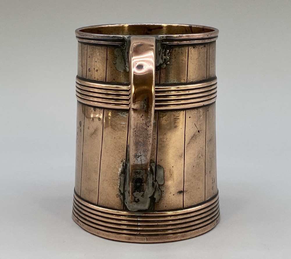 A tapered late Georgian copper tankard featuring horizontal reeded bands, vertical staved lines, and a curved nickel-plated handle. View IV