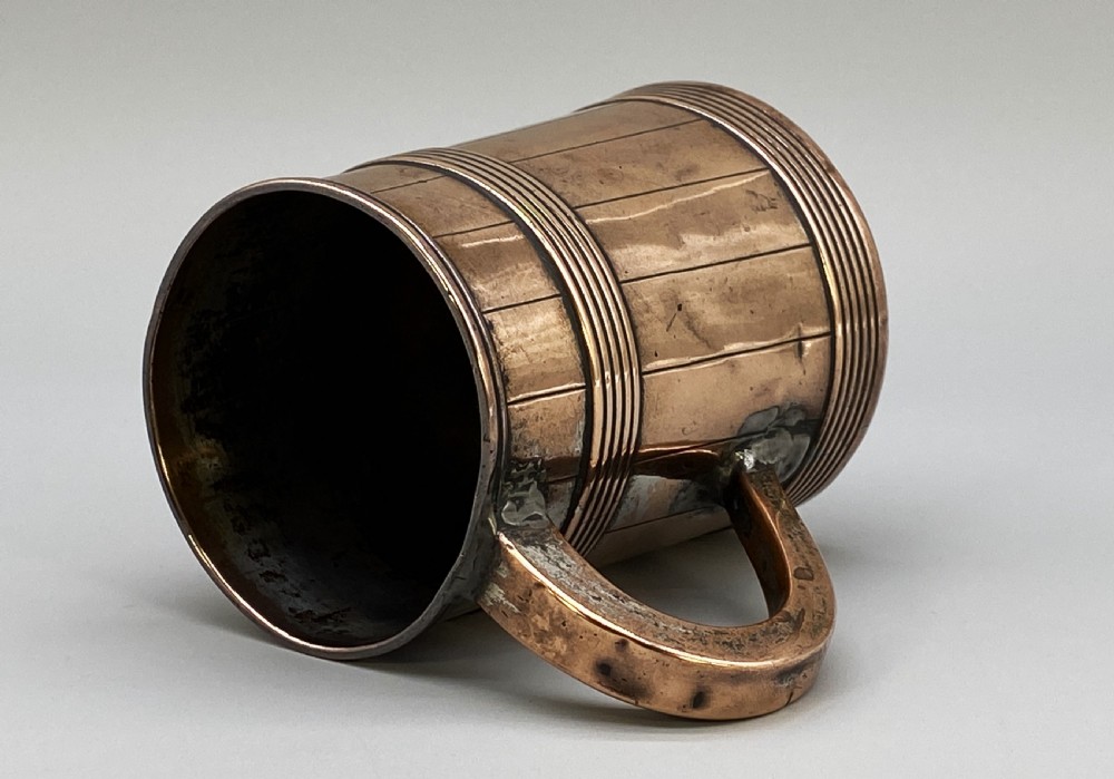 A tapered late Georgian copper tankard featuring horizontal reeded bands, vertical staved lines, and a curved nickel-plated handle. View VII