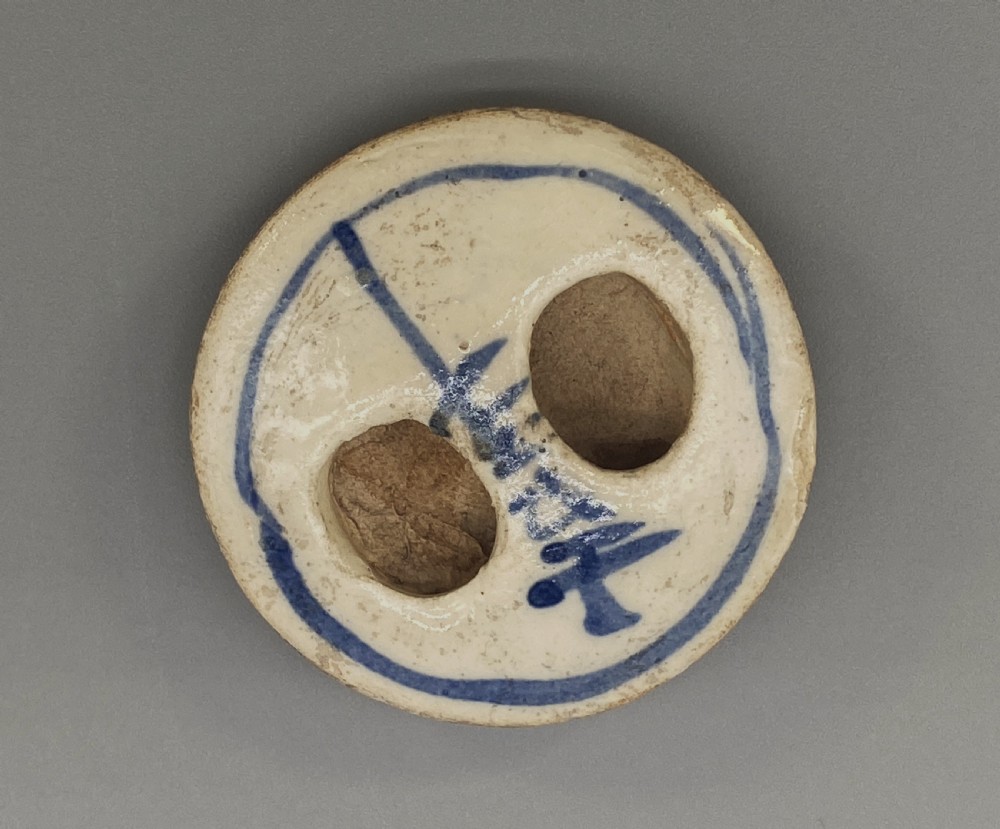 A cylindrical cream-coloured ceramic teapot decorated with hand-painted blue cobalt landscapes and featuring an overhead woven cane handle. View XIII