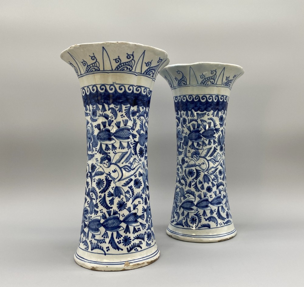 A pair of flared antique Dutch Delftware tin-glazed earthenware beaker vases decorated in cobalt blue and white with floral motifs and winged figures. View X