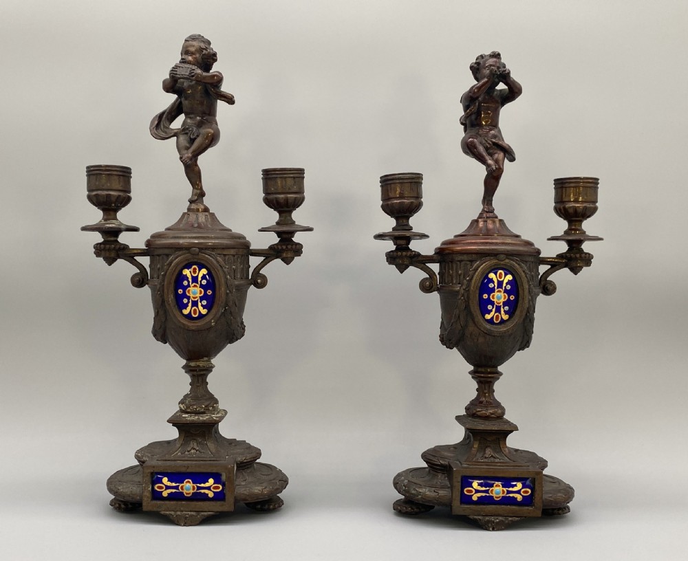 A pair of late 19th-century bronzed spelter twin-light candelabra featuring putti surmounts and urn-shaped bodies set with blue enamel plaques. View III