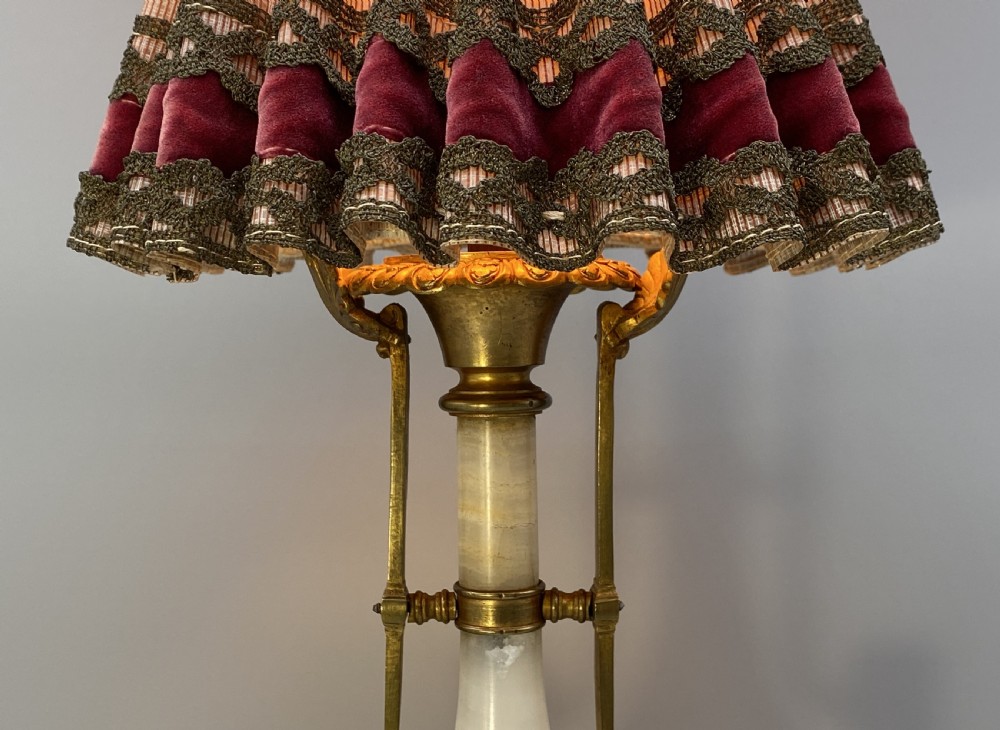 An antique French amphora-shaped white onyx table lamp with gilt metal handles and paw feet, topped with a pleated fabric shade. View VIII