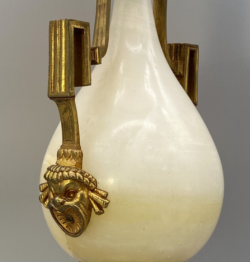 An antique French amphora-shaped white onyx table lamp with gilt metal handles and paw feet, topped with a pleated fabric shade. View X