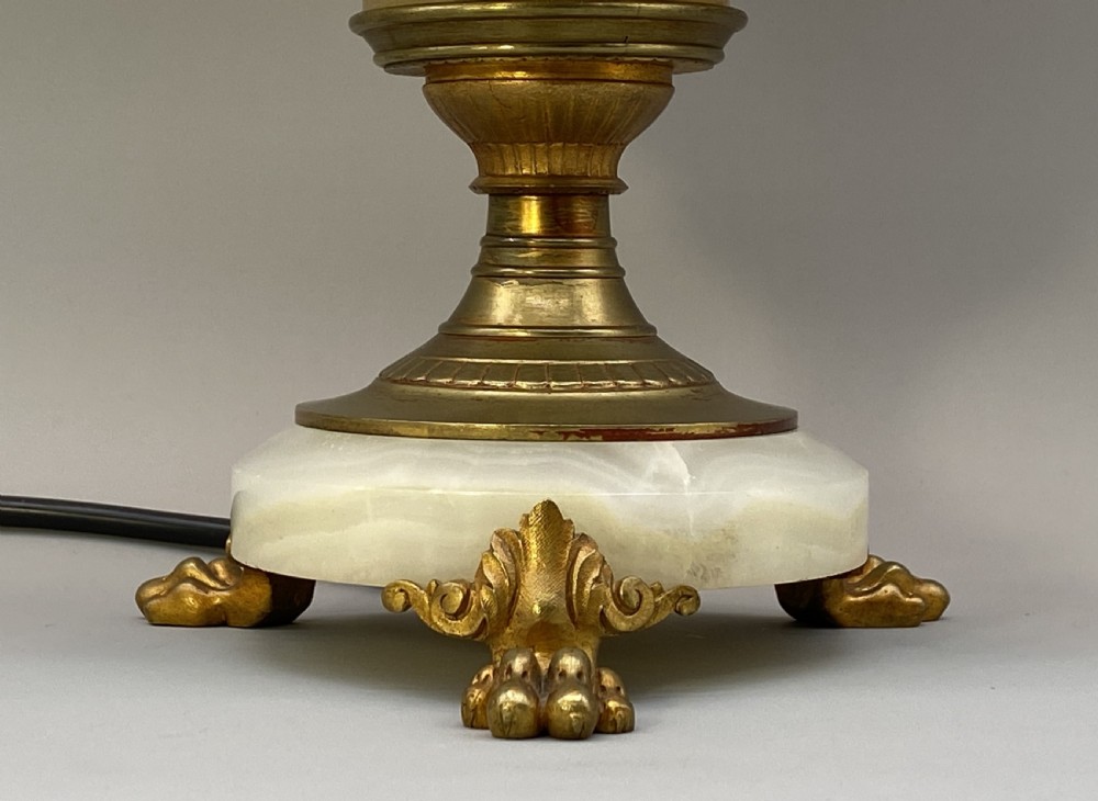 An antique French amphora-shaped white onyx table lamp with gilt metal handles and paw feet, topped with a pleated fabric shade. View XIV