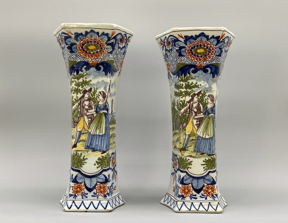 A pair of 18th-century octagonal flared Dutch Delft polychrome tin-glazed earthenware vases featuring hand-painted pastoral scenes of figures in landscape settings framed by floral motifs. View III