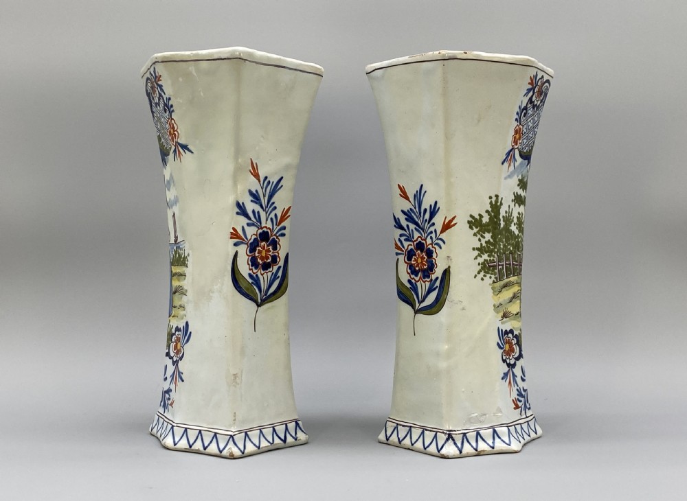 A pair of 18th-century octagonal flared Dutch Delft polychrome tin-glazed earthenware vases featuring hand-painted pastoral scenes of figures in landscape settings framed by floral motifs. View VII