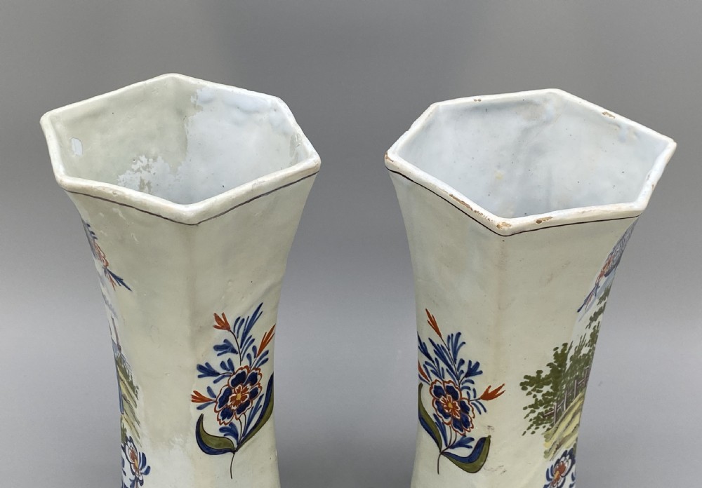 A pair of 18th-century octagonal flared Dutch Delft polychrome tin-glazed earthenware vases featuring hand-painted pastoral scenes of figures in landscape settings framed by floral motifs. View IX