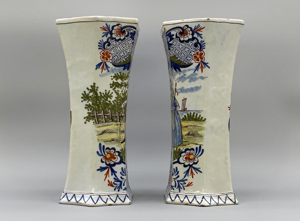 A pair of 18th-century octagonal flared Dutch Delft polychrome tin-glazed earthenware vases featuring hand-painted pastoral scenes of figures in landscape settings framed by floral motifs. View XI