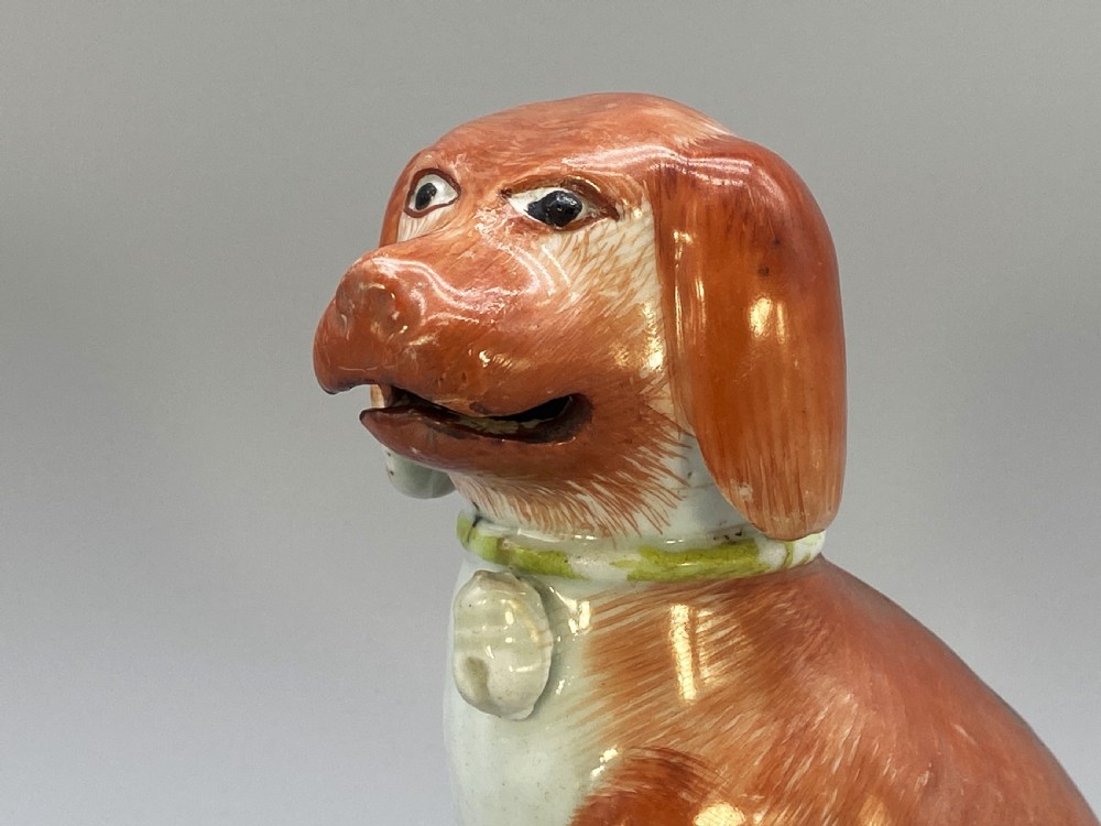 An 18th-century Chinese export porcelain figurine of a seated dog featuring iron-red fur painted details and a light green collar. View X
