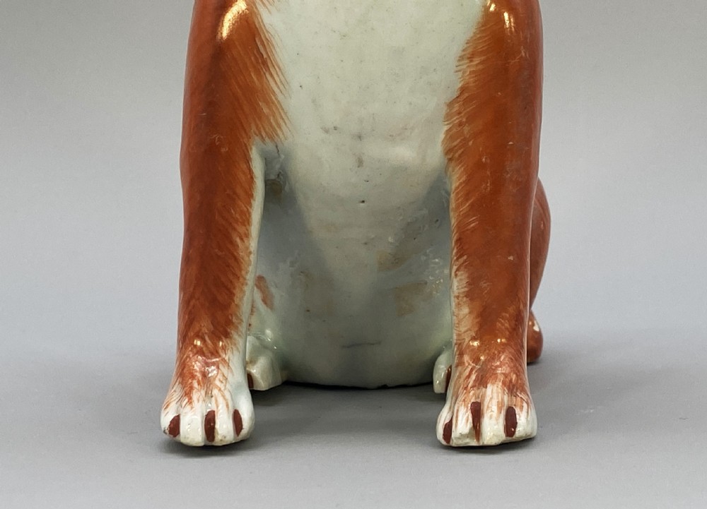 An 18th-century Chinese export porcelain figurine of a seated dog featuring iron-red fur painted details and a light green collar. View XV