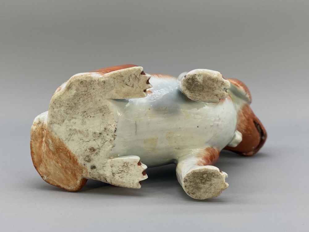 An 18th-century Chinese export porcelain figurine of a seated dog featuring iron-red fur painted details and a light green collar. View XVII