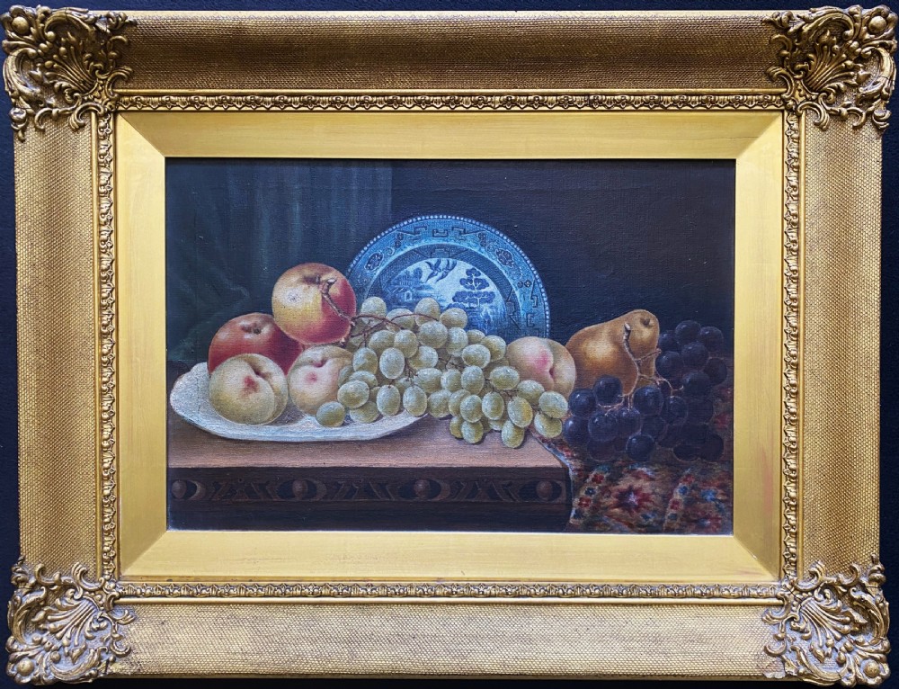 A late 19th-century still life oil painting on canvas depicting fruit and a blue patterned plate, framed in an ornate gilded frame.