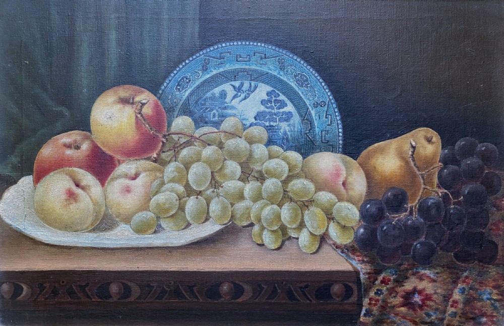 A late 19th-century still life oil painting on canvas depicting fruit and a blue patterned plate, framed in an ornate gilded frame. View II