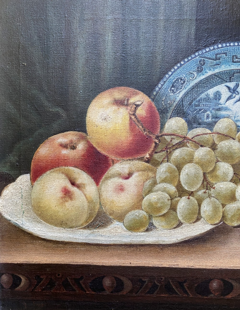 A late 19th-century still life oil painting on canvas depicting fruit and a blue patterned plate, framed in an ornate gilded frame. View VII