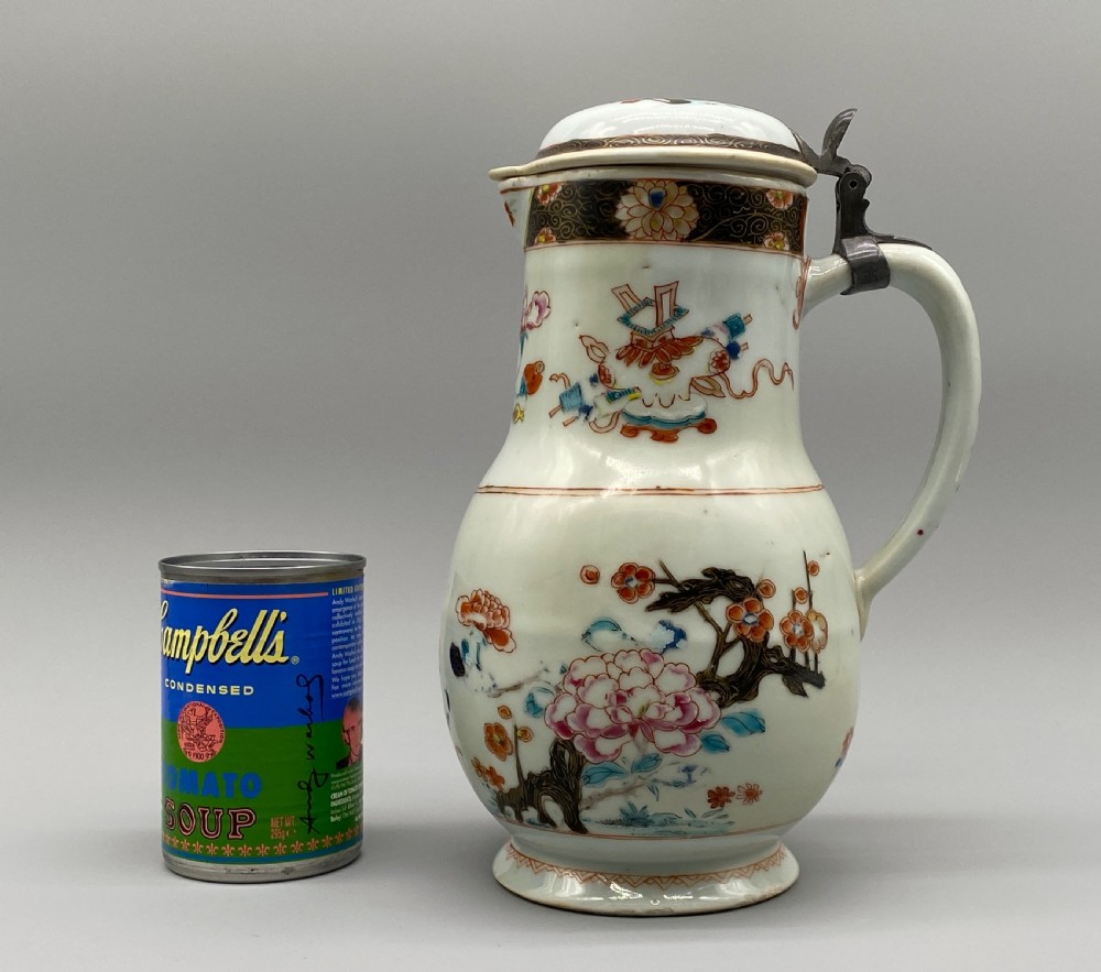 An 18th-century Chinese porcelain jug with hand-painted Famille Rose floral enamels, a metal-mounted lid, and a loop handle. View II