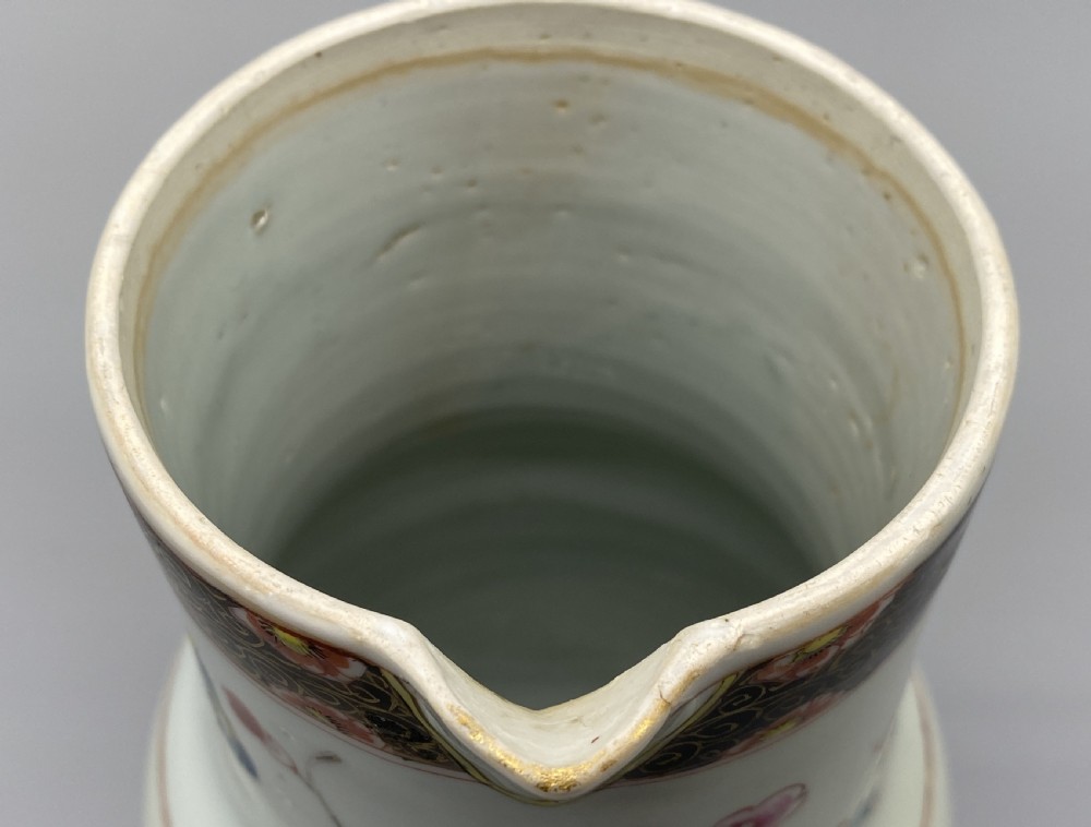 An 18th-century Chinese porcelain jug with hand-painted Famille Rose floral enamels, a metal-mounted lid, and a loop handle. View XVI