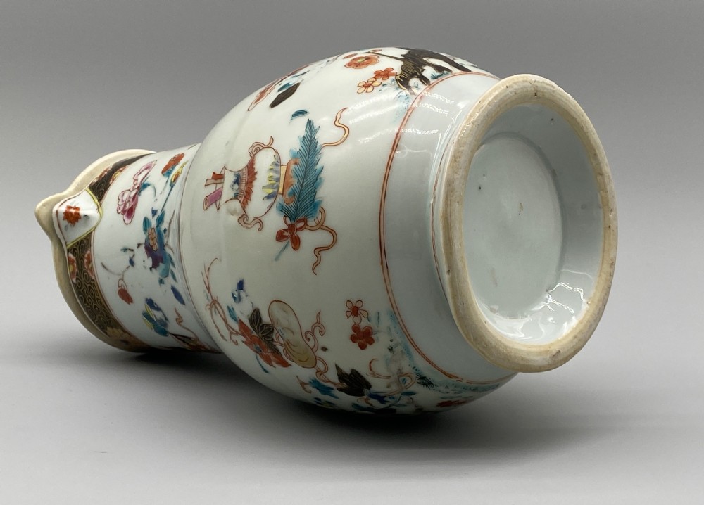 An 18th-century Chinese porcelain jug with hand-painted Famille Rose floral enamels, a metal-mounted lid, and a loop handle. View XVII