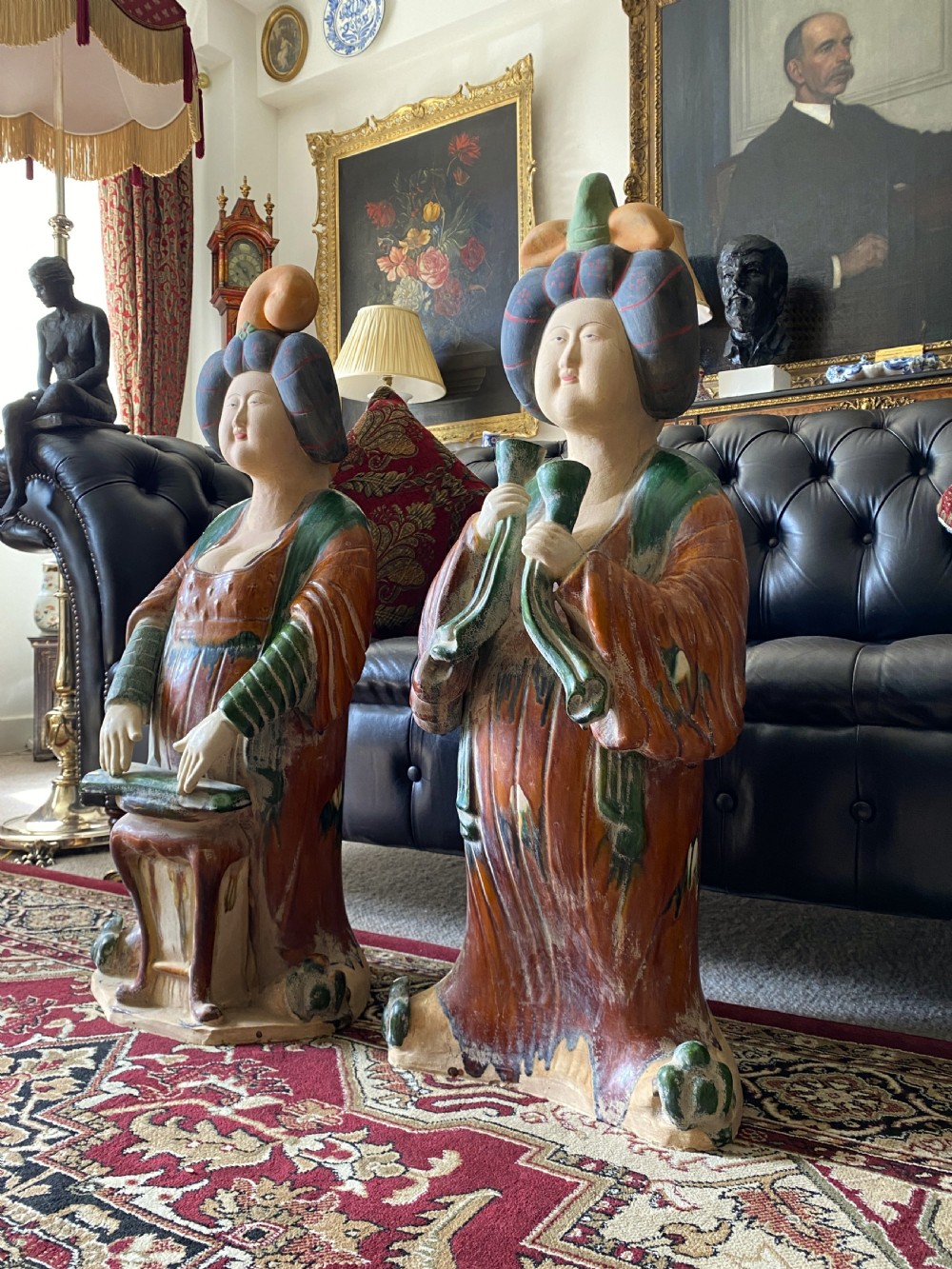 A pair of large Sancai glazed ceramic sculptures depicting Tang Dynasty style female court musicians in orange, green, and cream robes. View VI
