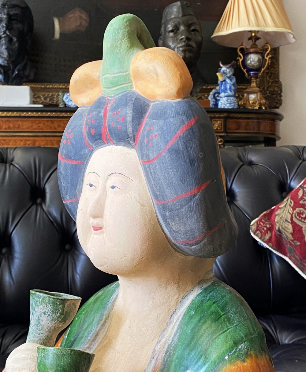 A pair of large Sancai glazed ceramic sculptures depicting Tang Dynasty style female court musicians in orange, green, and cream robes. View XX