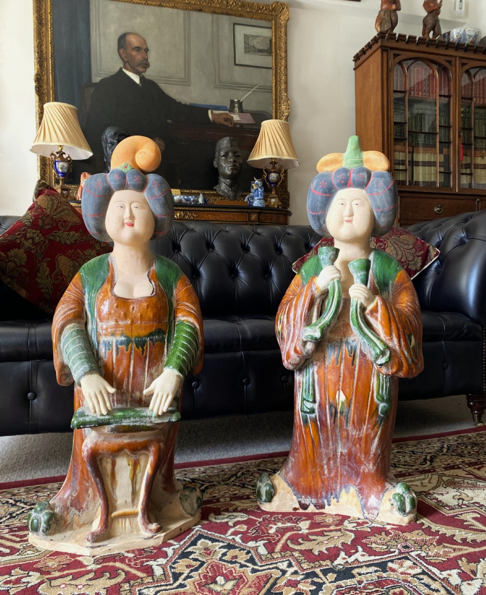 A pair of large Sancai glazed ceramic sculptures depicting Tang Dynasty style female court musicians in orange, green, and cream robes. View XXIII