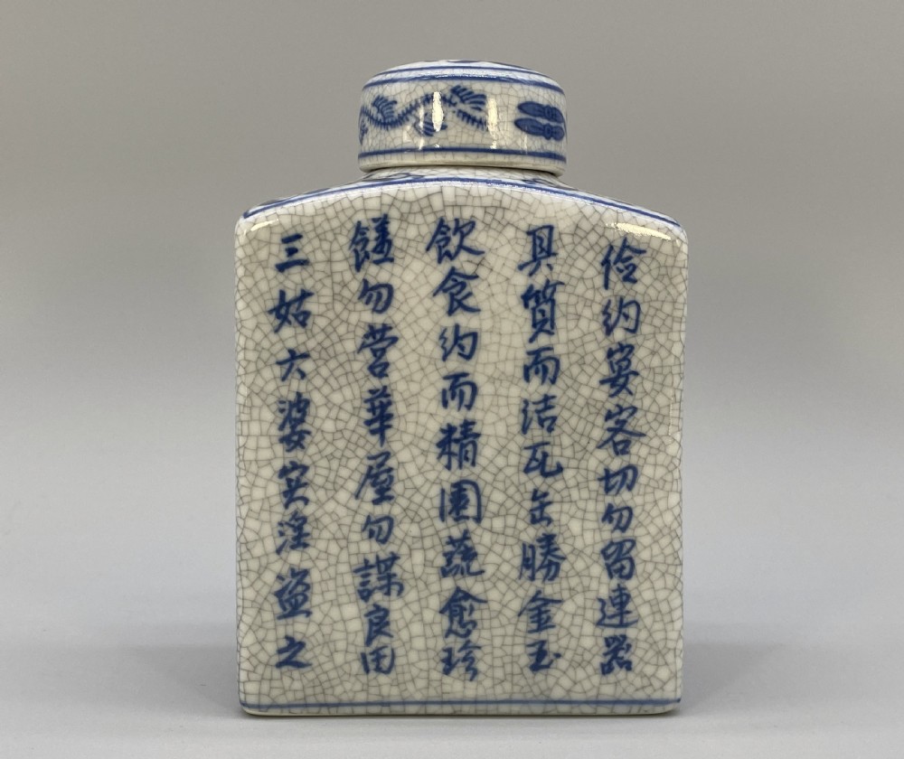 A rectangular blue and white crackle-glazed porcelain canister with a fitted lid, featuring vertical columns of hand-painted Chinese calligraphy. View II