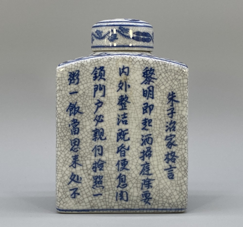 A rectangular blue and white crackle-glazed porcelain canister with a fitted lid, featuring vertical columns of hand-painted Chinese calligraphy. View VII