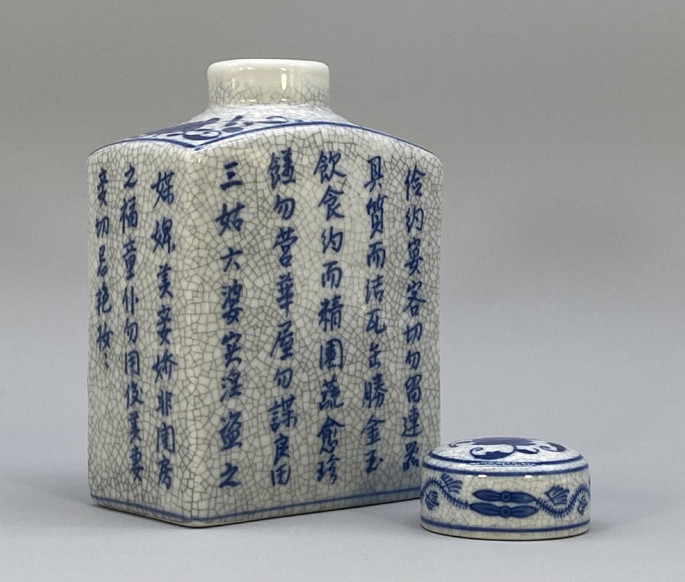 A rectangular blue and white crackle-glazed porcelain canister with a fitted lid, featuring vertical columns of hand-painted Chinese calligraphy. View X