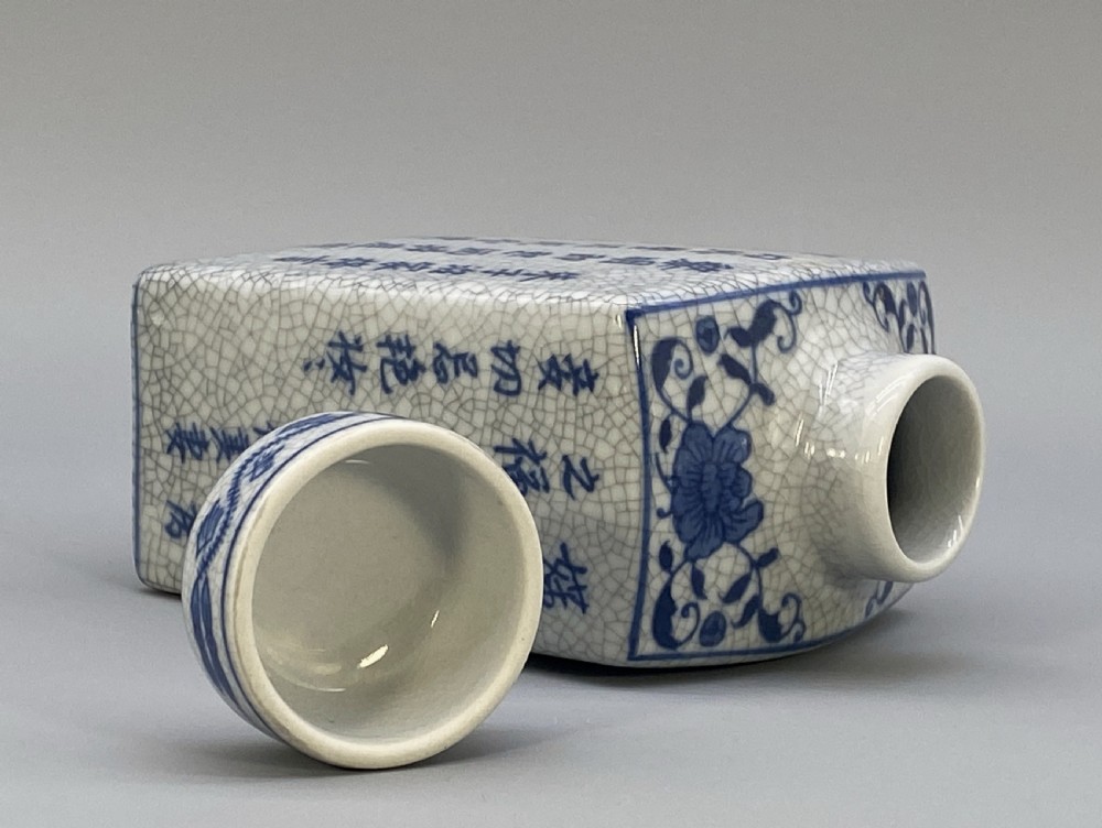 A rectangular blue and white crackle-glazed porcelain canister with a fitted lid, featuring vertical columns of hand-painted Chinese calligraphy. View XII
