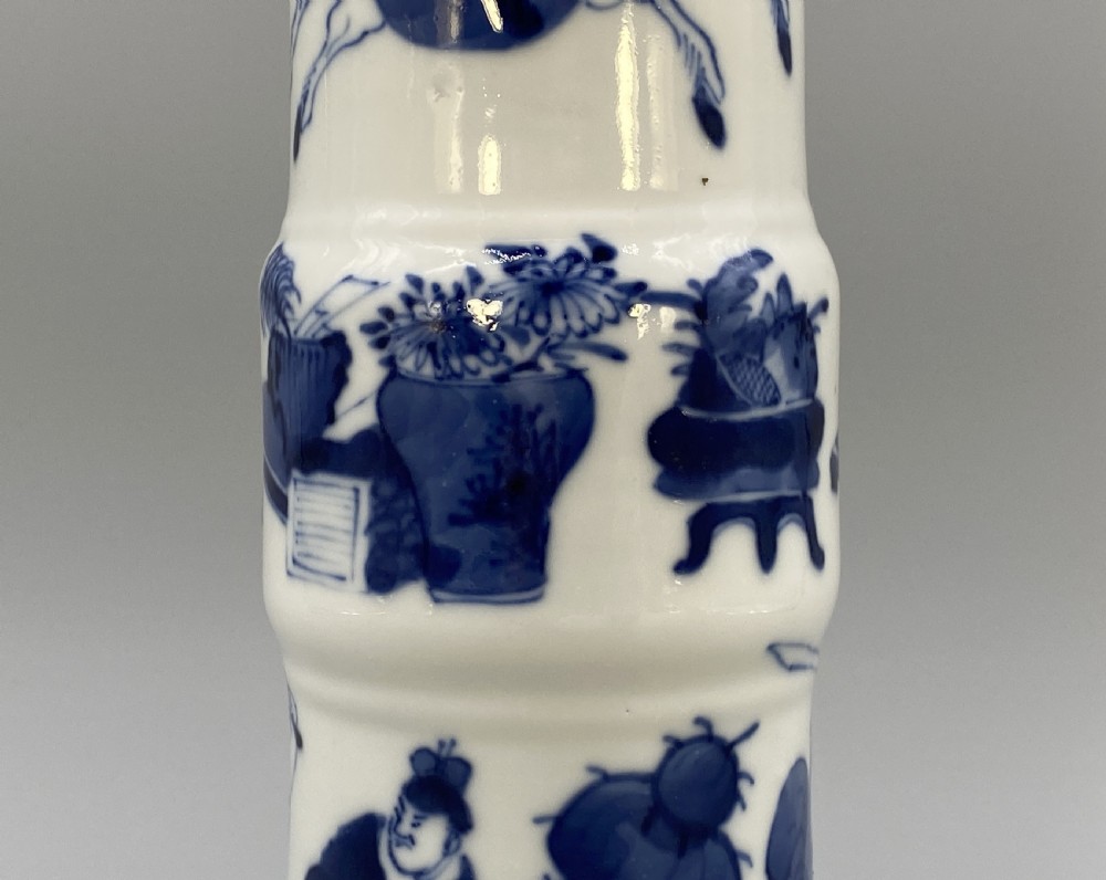 A tall, slender Chinese porcelain beaker vase painted in underglaze cobalt blue featuring equestrian figures and traditional motifs against a smooth white glaze. View V