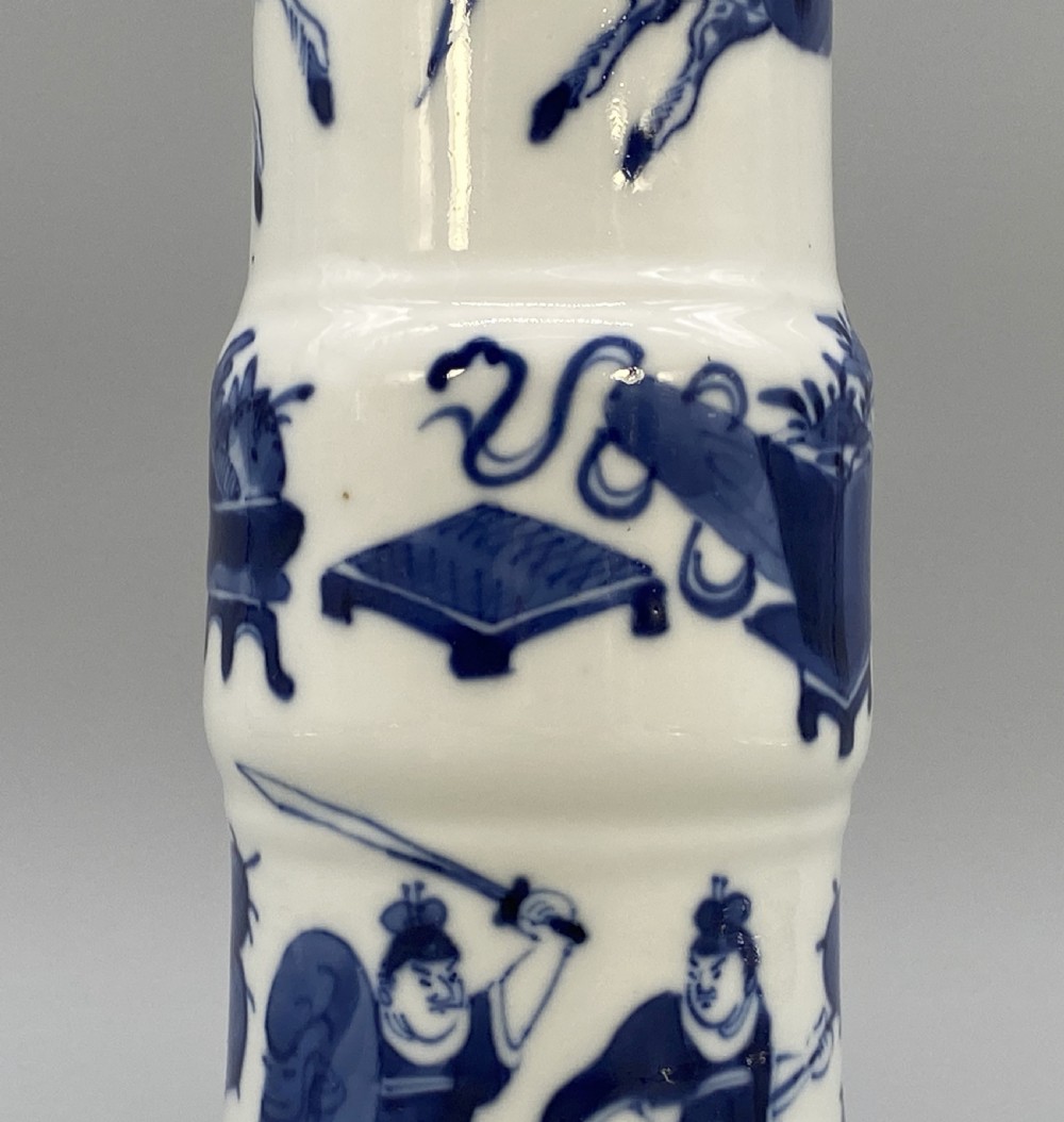 A tall, slender Chinese porcelain beaker vase painted in underglaze cobalt blue featuring equestrian figures and traditional motifs against a smooth white glaze. View XI