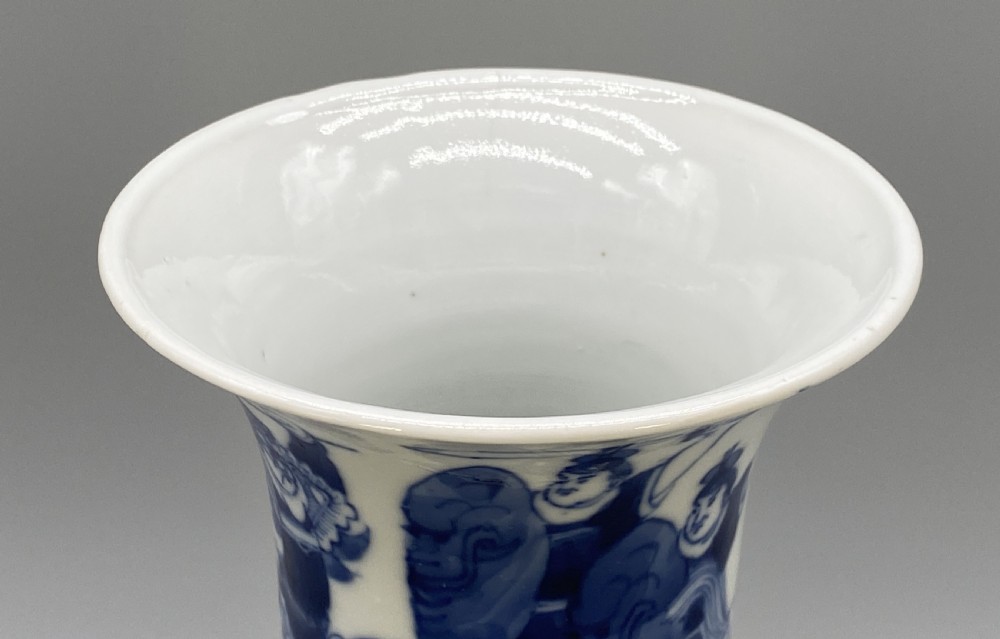 A tall, slender Chinese porcelain beaker vase painted in underglaze cobalt blue featuring equestrian figures and traditional motifs against a smooth white glaze. View XVI