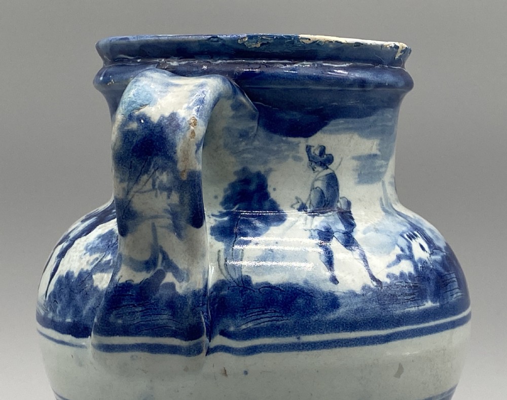 An 18th-century Italian Savona majolica wet drug jar featuring hand-painted cobalt blue landscapes, a single side handle, a raised spout, and a pedestal base. View X