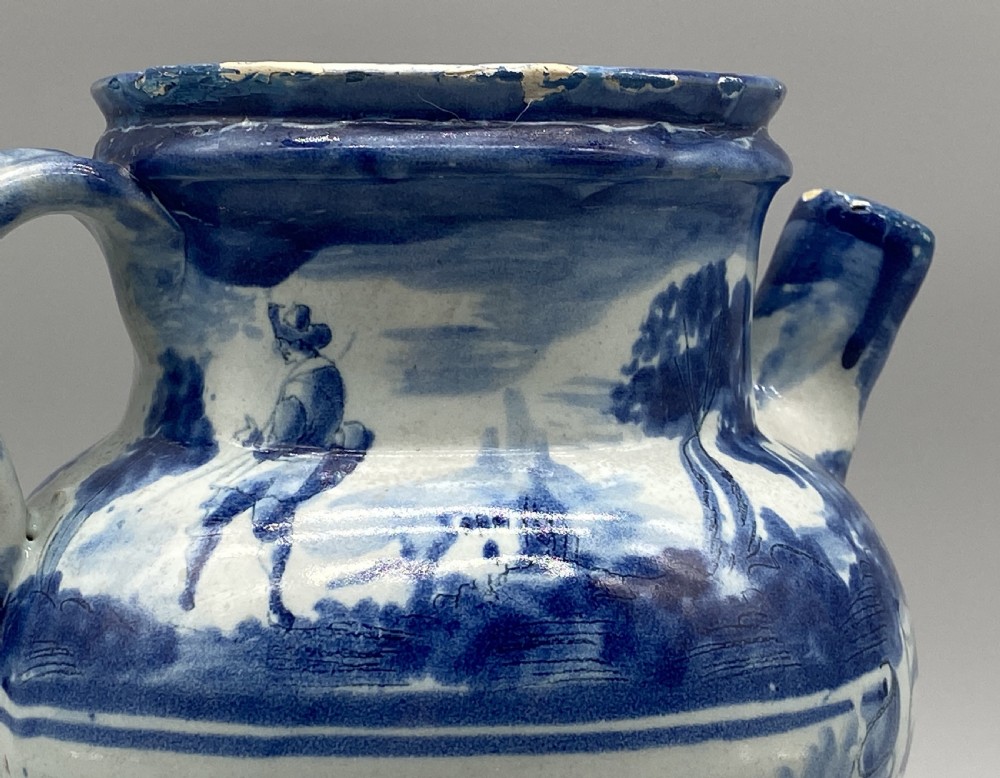 An 18th-century Italian Savona majolica wet drug jar featuring hand-painted cobalt blue landscapes, a single side handle, a raised spout, and a pedestal base. View XII