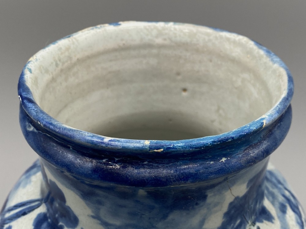 An 18th-century Italian Savona majolica wet drug jar featuring hand-painted cobalt blue landscapes, a single side handle, a raised spout, and a pedestal base. View XV
