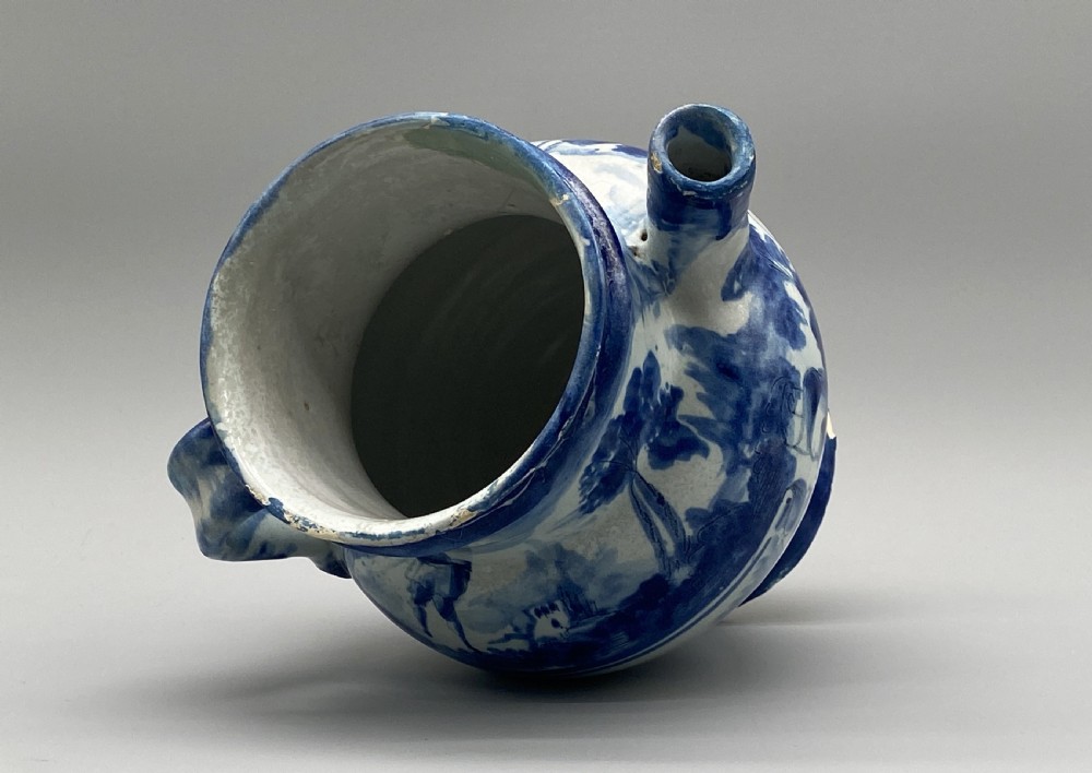 An 18th-century Italian Savona majolica wet drug jar featuring hand-painted cobalt blue landscapes, a single side handle, a raised spout, and a pedestal base. View XVII