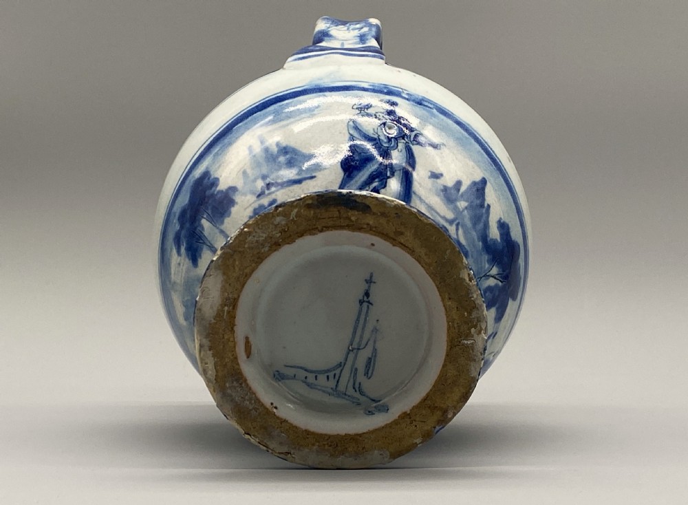 An 18th-century Italian Savona majolica wet drug jar featuring hand-painted cobalt blue landscapes, a single side handle, a raised spout, and a pedestal base. View XVIII