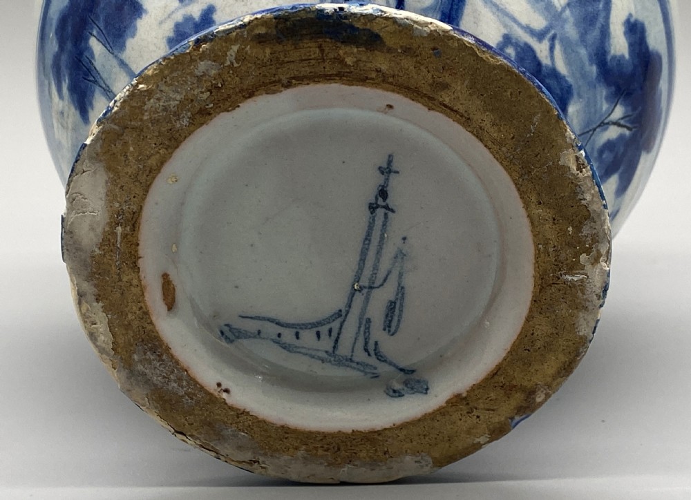 An 18th-century Italian Savona majolica wet drug jar featuring hand-painted cobalt blue landscapes, a single side handle, a raised spout, and a pedestal base. View XX