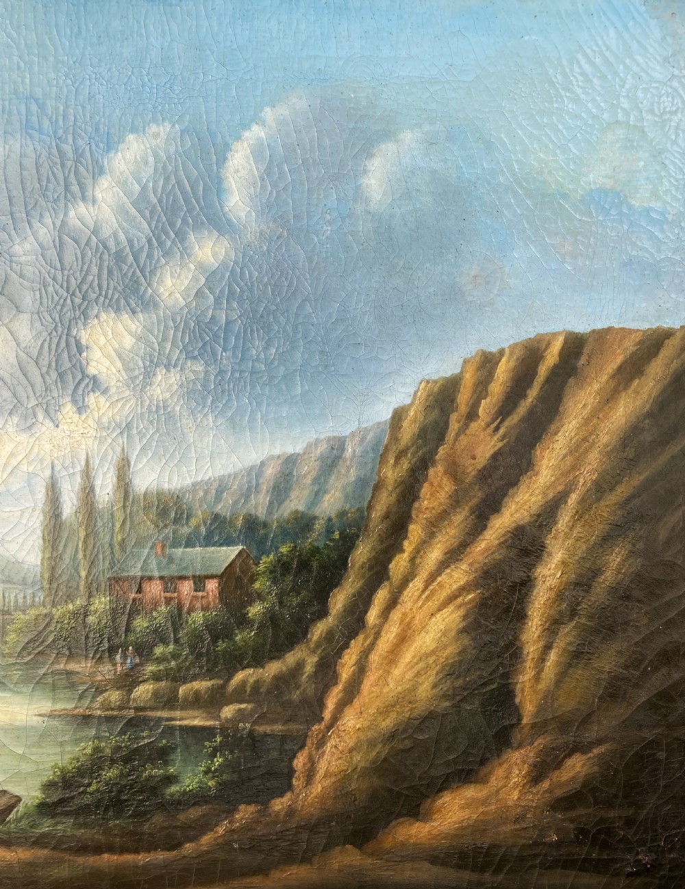 A 19th-century Italian School oil painting depicting a lakeside landscape with figures in a boat, towering cliffs, and a clouded blue sky inside a gilt frame. View VI