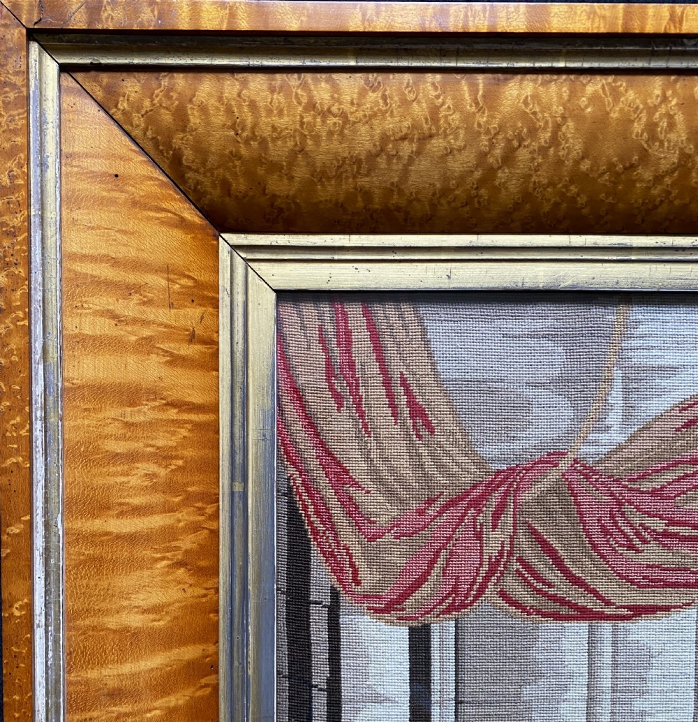 An antique Biedermeier picture frame crafted from birds eye maple veneer with an inner gilt slip enclosing a needlework tapestry. View III